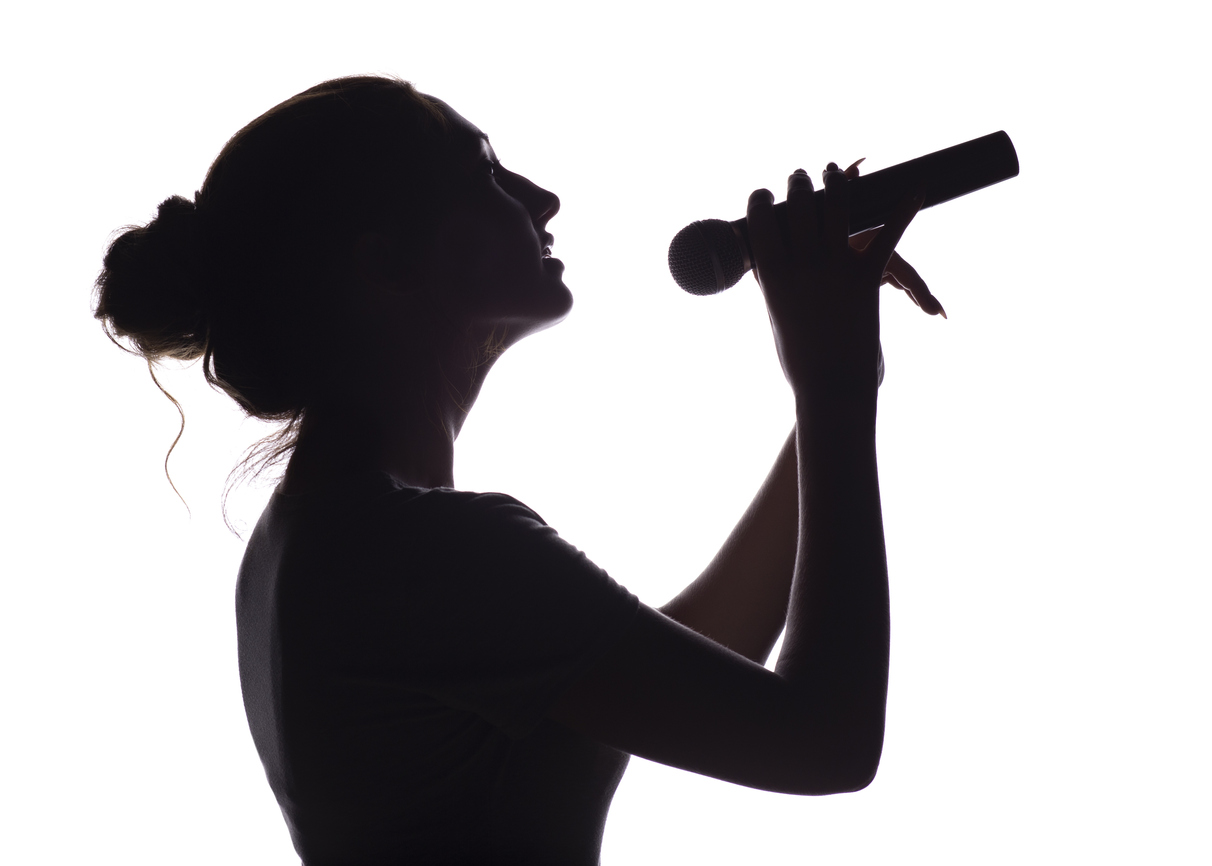 Silhouette of woman singing into a microphone. Beverly Hills plastic surgery